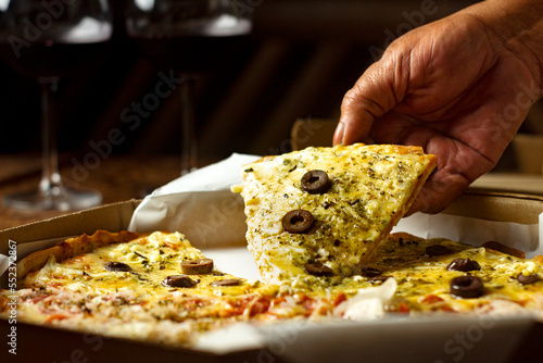 Pizza sendo levantada com uma mão photo