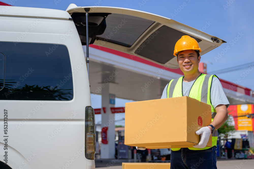 male worker driving parcel delivery Standing holding a cardboard box at the delivery van work for delivery driver home service male worker driving parcel delivery Standing holding a cardboard box at the delivery van work for delivery driver home service