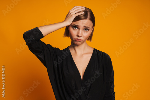 Young displeased woman with headache holding her head