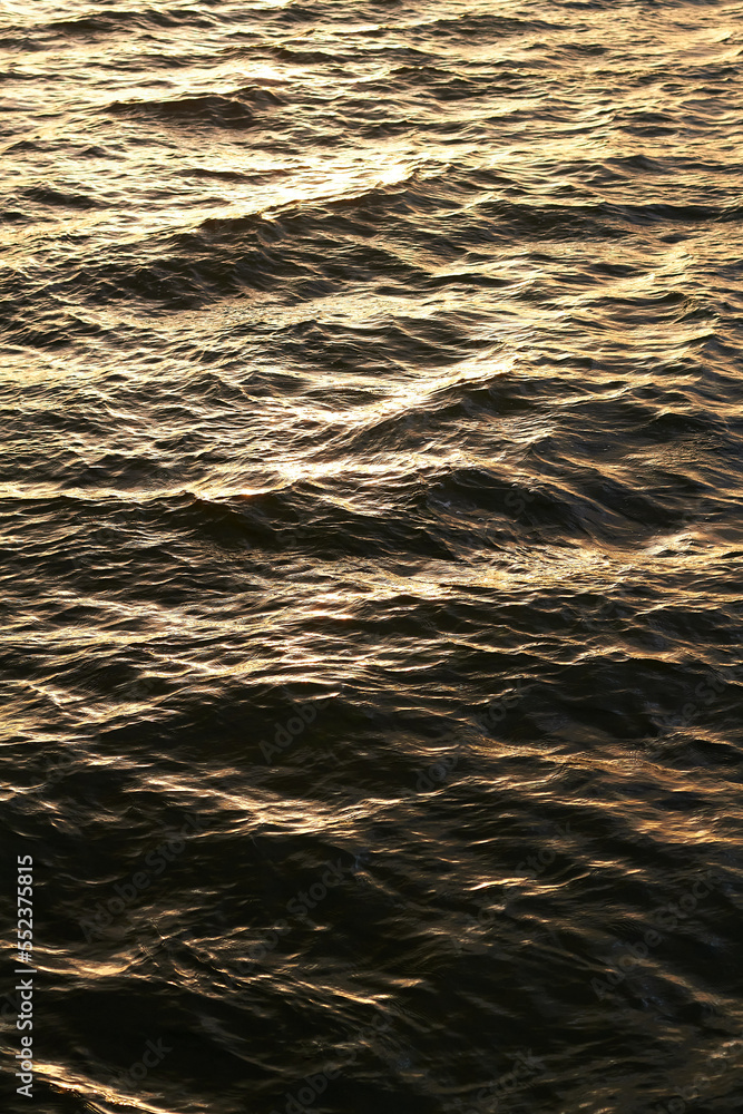 Ripple river water surface with golden sunset light. close up Ripple river water surface with golden sunset light. close up