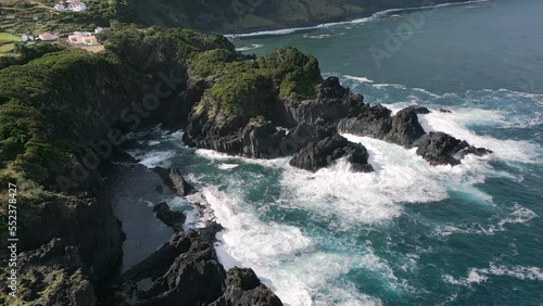 Stationary aerial view of a scenic coastline with volcanic rock in São Jorge, Azores photo