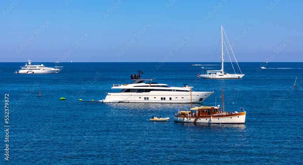 Panoramic view of harbor and yachts with French riviera shore in background seen from Azure Cost of Mediterranean Sea in Antibes resort town in France Panoramic view of harbor and yachts with French riviera shore in background seen from Azure Cost of Mediterranean Sea in Antibes resort town in France