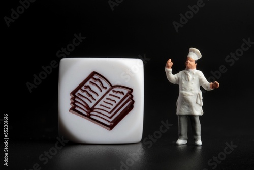 miniature figurine of a chef on a black background with icon