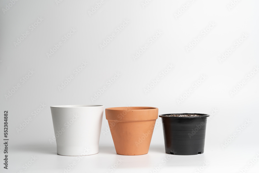 Various pot comparison in isolated white background. Ceramic, Terracotta and Plastic pots comparison Various pot comparison in isolated white background. Ceramic, Terracotta and Plastic pots comparison