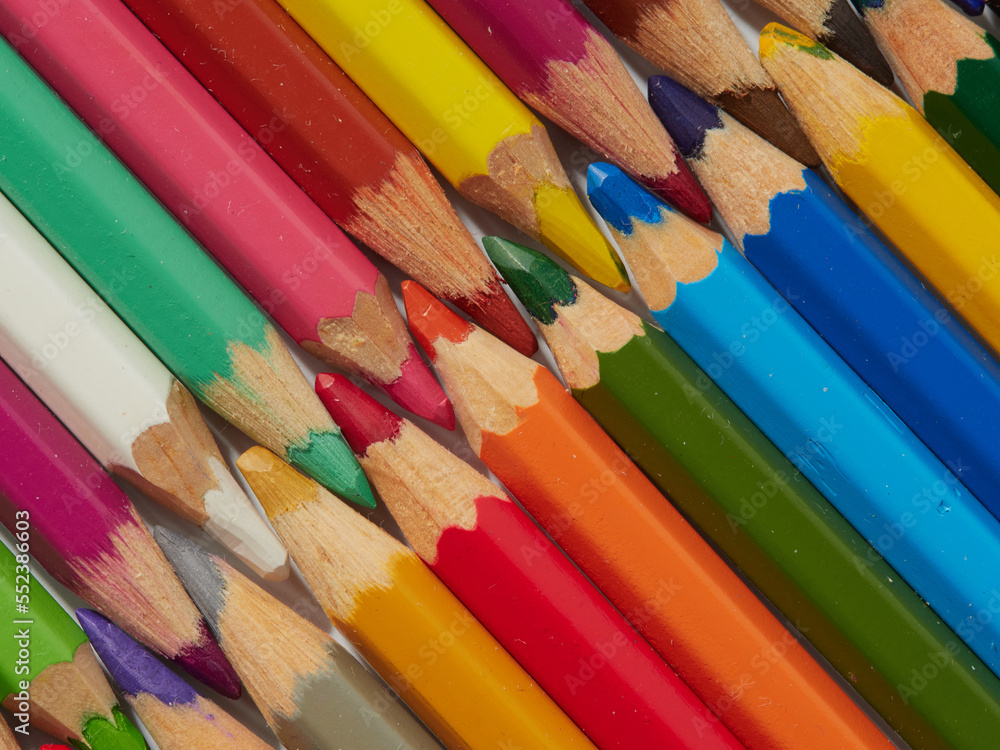 Naklejka premium Colored pencils background. Colored pencils on a white background.