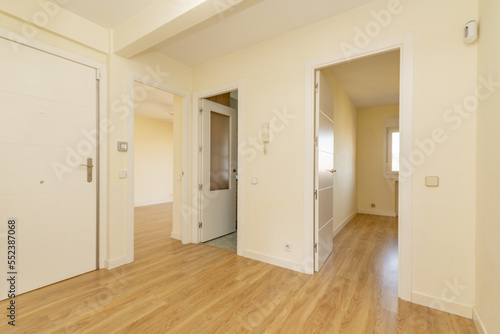 distributor of a house with armored access door  and access to rooms with white lacquered wooden doors and floating oak wood flooring