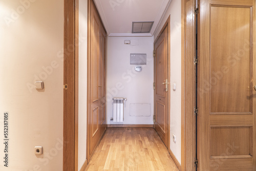 Entrance hall and housing distributor with armored access door  and access to rooms with oak doors  built-in wardrobes of the same material and parquet floors.