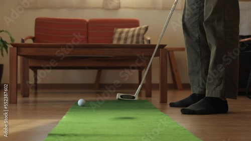 Father practicing putting at home.