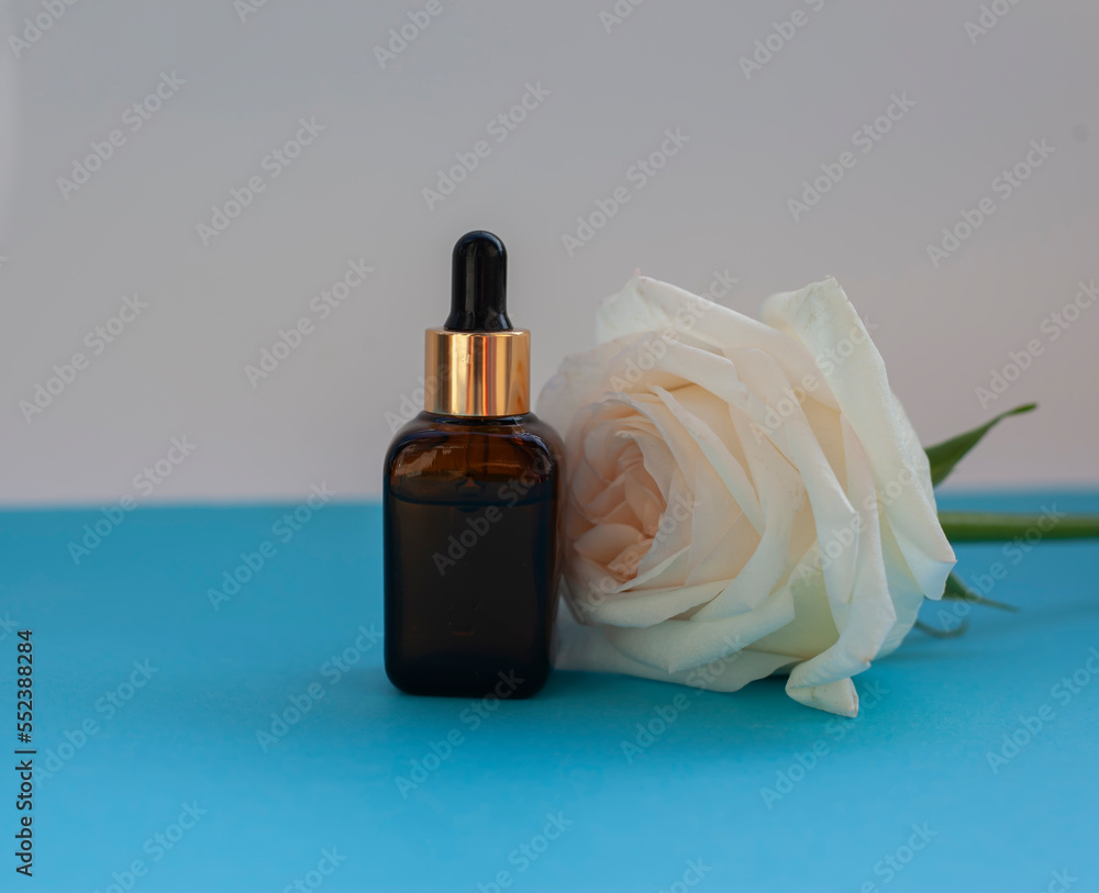Rose essential oil close-up on a blue background. Rose essential oil close-up on a blue background.
