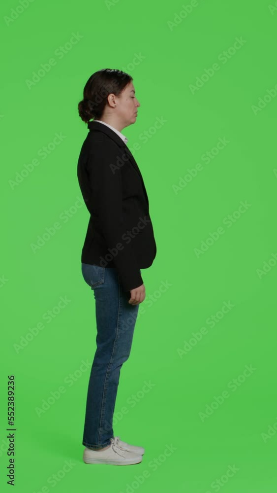 Vertical video: Profile of displeased company manager acting sad or upset in studio, feeling disappointed over full body greenscreen. Discontent female employee being negative posing on camera over Vertical video: Profile of displeased company manager acting sad or upset in studio, feeling disappointed over full body greenscreen. Discontent female employee being negative posing on camera over