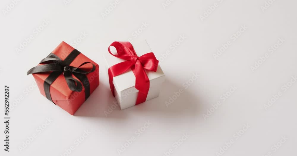 Video of white and red gift boxes tied with ribbons, on white background with copy space Video of white and red gift boxes tied with ribbons, on white background with copy space