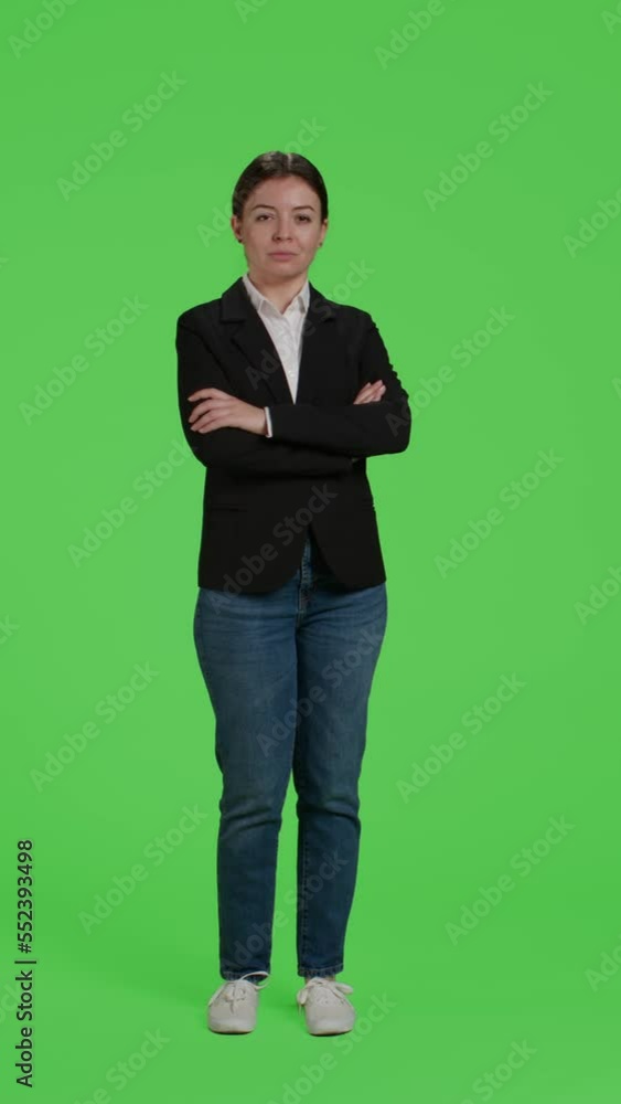 Vertical video: Front view of young businesswoman acting confident wearing suit, being friendly and stylish over full body greenscreen. Female employee feeling positive working at corporate job Vertical video: Front view of young businesswoman acting confident wearing suit, being friendly and stylish over full body greenscreen. Female employee feeling positive working at corporate job
