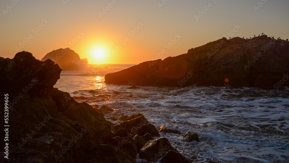 Sunset over rocky Pacific Ocean Shoreline, California
