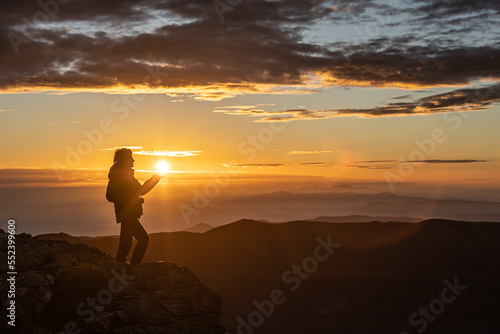 girl catching the sun at sunset with the golden sky  selective focus  blur  blurred