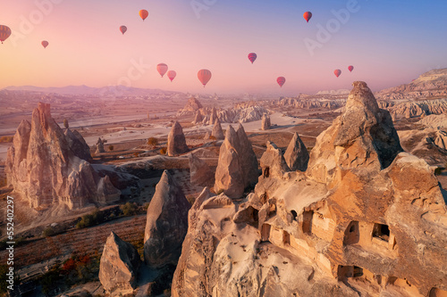 Autumn landscape Cappadocia hot air balloons and stone old cave house in Goreme national park Turkey. Aerial top view travel landmark trip concept