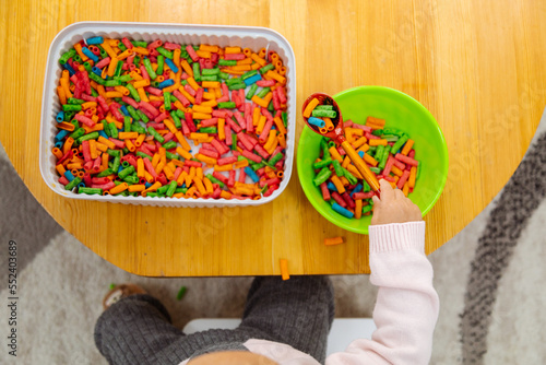 Sensory game sorting colored pasta photo