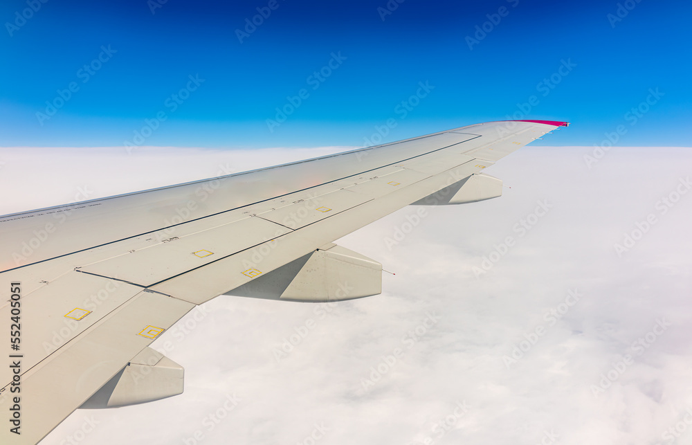 View from the airplane window at a beautiful cloudy sky and the airplane wing View from the airplane window at a beautiful cloudy sky and the airplane wing