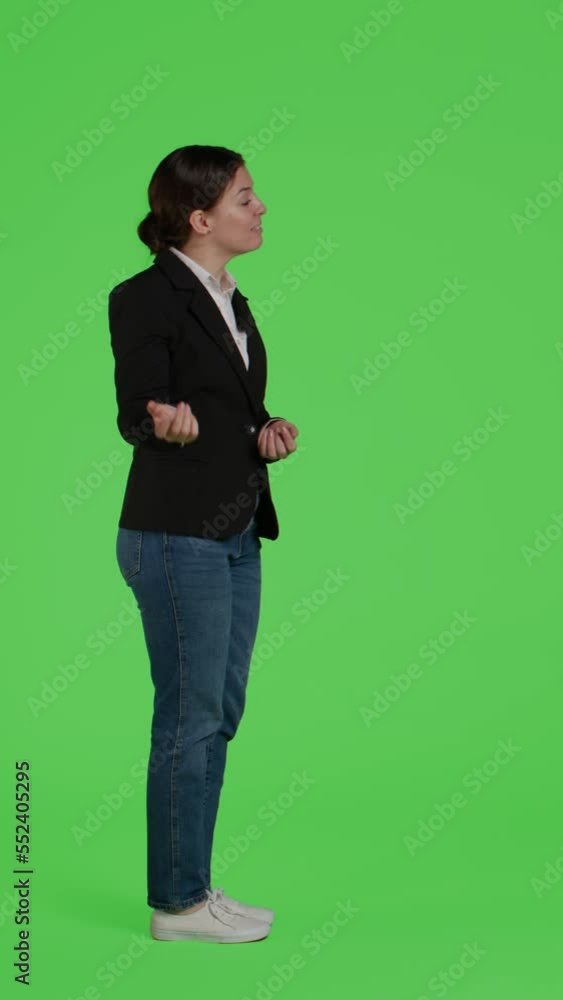 Vertical video: Profile of corporate employee in suit doing advertisement over full body green screen background, showing ad or icon in studio. Office worker indicating presentation example standing Vertical video: Profile of corporate employee in suit doing advertisement over full body green screen background, showing ad or icon in studio. Office worker indicating presentation example standing