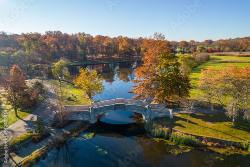 Autumn park bridge over a pond