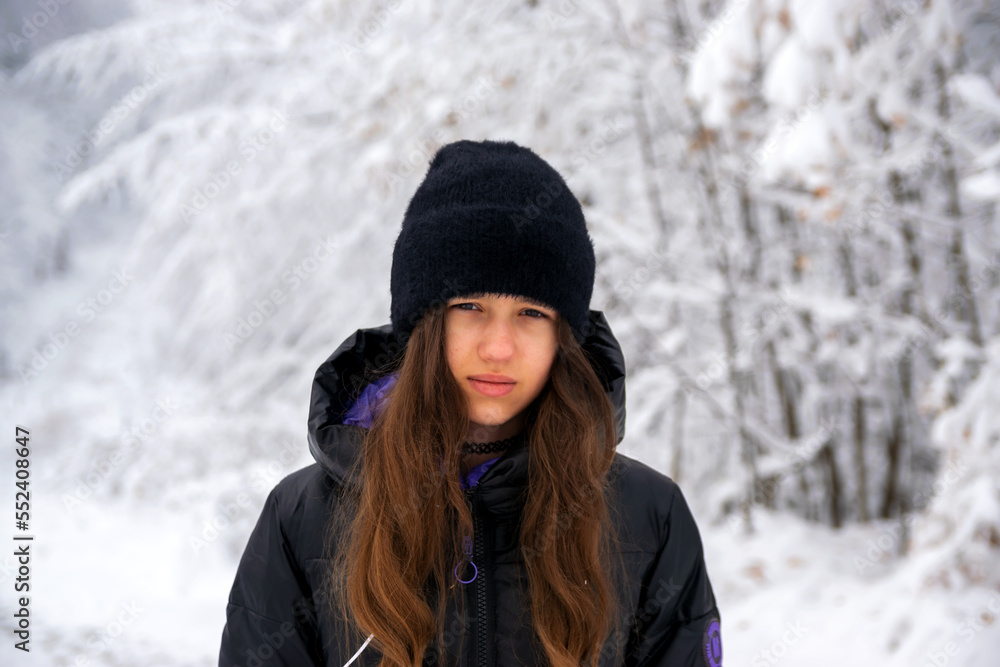 Winter, portrait of a girl on a mountain in the forest.