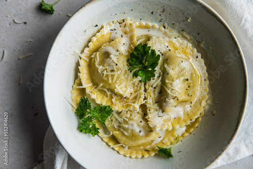 Fotografija Mezzelune filled with parmesan and asparagus with creamy sauce and grated parmesan
