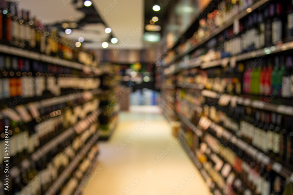 Blurred image of wine shelves display in supermarket