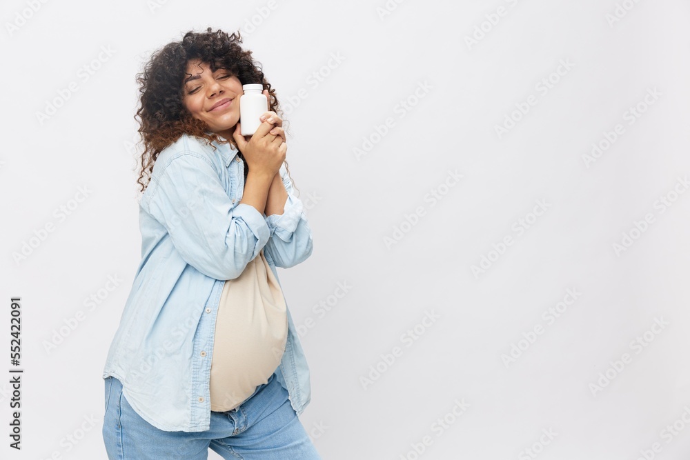 Pregnant woman smile with teeth jar of pregnancy vitamin pills in hands, alpha lipoic acid, vitamin complex on white isolated background copy space, free background Pregnant woman smile with teeth jar of pregnancy vitamin pills in hands, alpha lipoic acid, vitamin complex on white isolated background copy space, free background