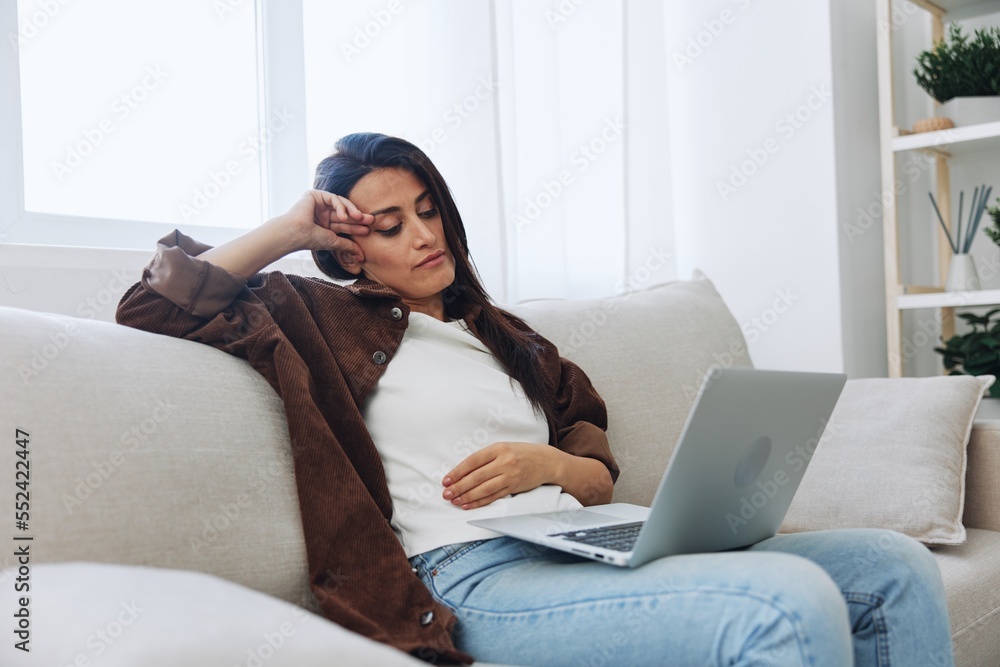 Woman freelancer on day off sitting on sofa with laptop at home online video chat call, smile Woman freelancer on day off sitting on sofa with laptop at home online video chat call, smile
