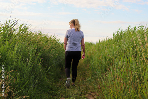 A woman walking early in the morning. She is thinking and contemplating, this exercise is good for both her physical and mental health.