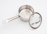 Stainless saucepan with glass lid  on a gray background