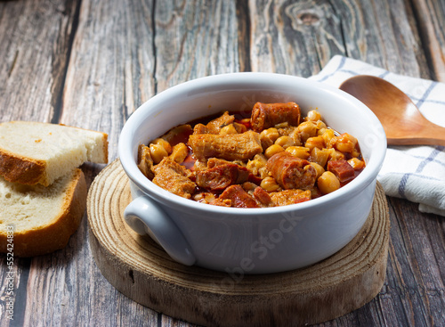 Tripe casserole on bottom and wooden spoon. Winter comfort food. (Callos a la madrileña)