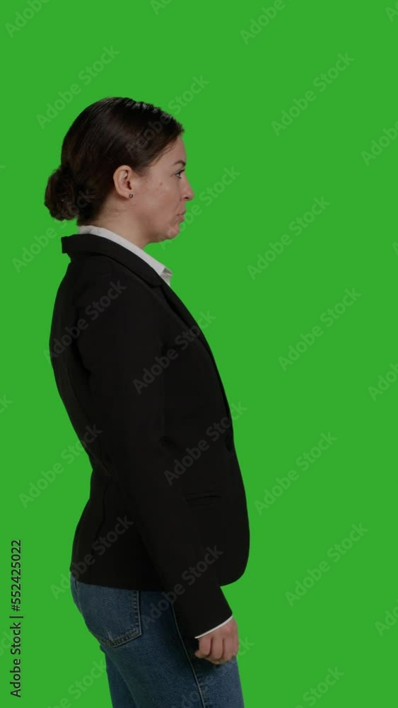 Vertical video: Profile close up of female manager wearing office suit in studio, acting stylish and confident on camera. Businesswoman with corporate job standing over isolated greenscreen background Vertical video: Profile close up of female manager wearing office suit in studio, acting stylish and confident on camera. Businesswoman with corporate job standing over isolated greenscreen background