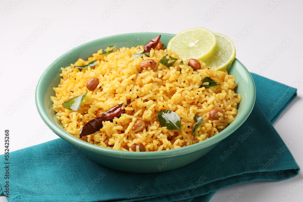 Lemon Rice or fodnicha bhat is South Indian turmeric rice or maharashtrian recipe using leftover rice garnished with nuts curry leaves and lemon juice Lemon Rice or fodnicha bhat is South Indian turmeric rice or maharashtrian recipe using leftover rice garnished with nuts curry leaves and lemon juice