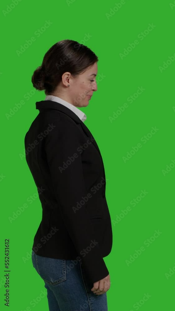 Vertical video: Profile close up of female manager wearing office suit in studio, acting stylish and confident on camera. Businesswoman with corporate job standing over isolated greenscreen background Vertical video: Profile close up of female manager wearing office suit in studio, acting stylish and confident on camera. Businesswoman with corporate job standing over isolated greenscreen background