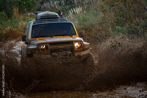 Veículo 4x4 cruzando lama, durante rali e espirrando lama para todos os lados. © Marcos