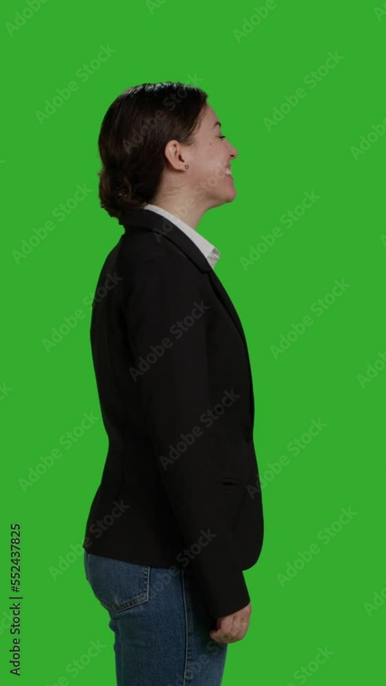 Vertical video: Profile close up of female manager wearing office suit in studio, acting stylish and confident on camera. Businesswoman with corporate job standing over isolated greenscreen background Vertical video: Profile close up of female manager wearing office suit in studio, acting stylish and confident on camera. Businesswoman with corporate job standing over isolated greenscreen background