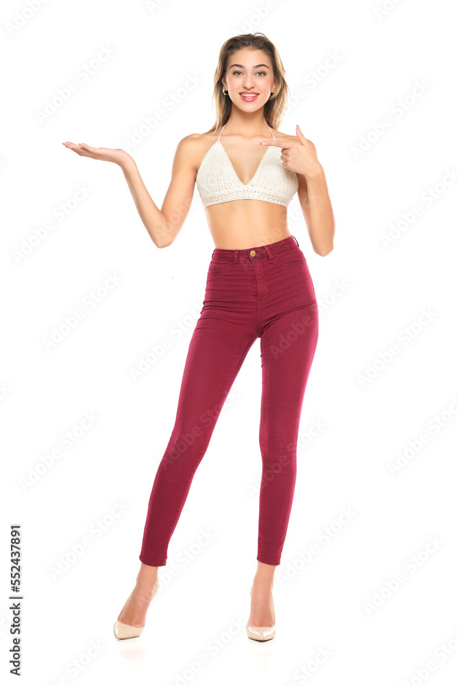 Smiling Woman In Burgundy Jeans And Top Presenting Something On her Empty Palm On A White Background Smiling Woman In Burgundy Jeans And Top Presenting Something On her Empty Palm On A White Background