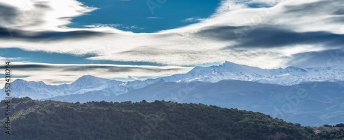 Beautiful lenticular clouds over the snowy peaks of Sierra Nevada (Granada, Spain)