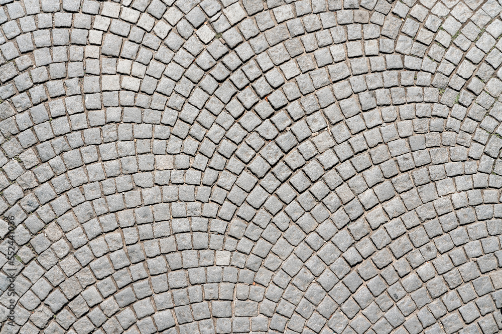 Grey cobblestone pavement abstract background surface top close up view