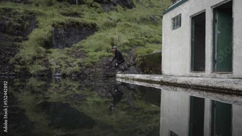 Wallpaper Mural young woman touches the water at  Seljavallalaug Swimming Pool with reflection Torontodigital.ca