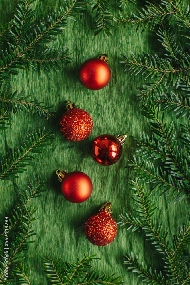 Beautiful Christmas ornaments and spruce branches on a green background.