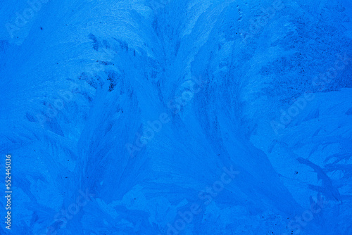 Abstract background of frosty ice patterns on glass. Close-up macro shot.