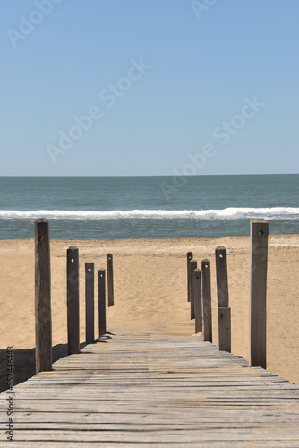 Panoramic view of a wooden path that leads to the beach. 