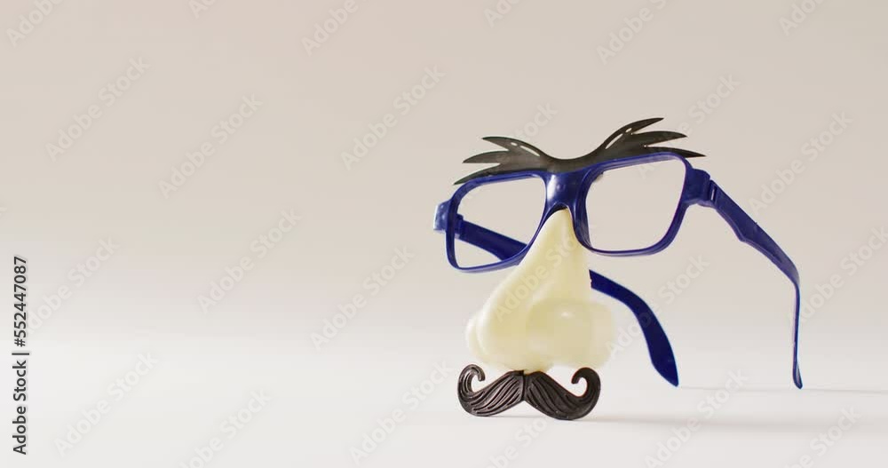 Video of attached plastic eyebrows, glasses, nose and moustache on white background with copy space Video of attached plastic eyebrows, glasses, nose and moustache on white background with copy space