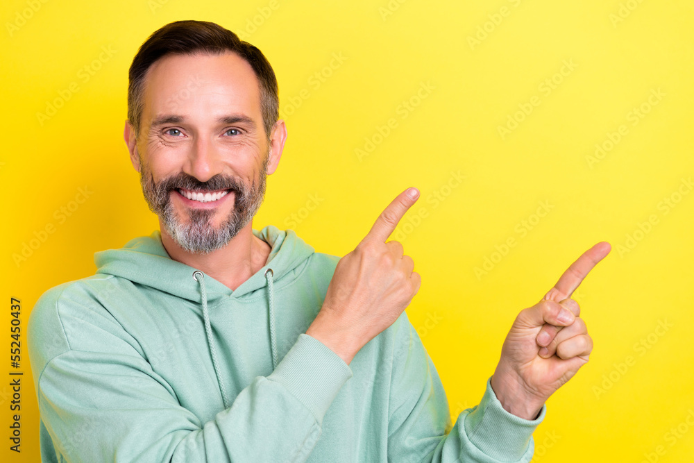 Photo of optimistic promoter toothy beaming smile fingers direct mockup new brand electronics best price isolated on yellow color background Photo of optimistic promoter toothy beaming smile fingers direct mockup new brand electronics best price isolated on yellow color background