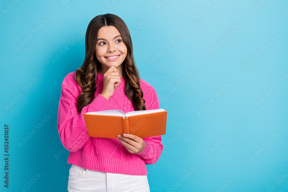 Photo of dreamy intelligent girl dressed knit pullover looking empty space arm hand chin holding book isolated blue color background Photo of dreamy intelligent girl dressed knit pullover looking empty space arm hand chin holding book isolated blue color background