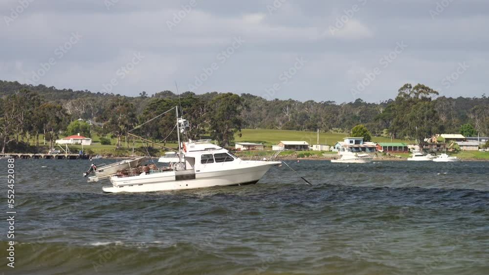 fishing boat moored to a buoy in rough swell and waves fishing boat moored to a buoy in rough swell and waves