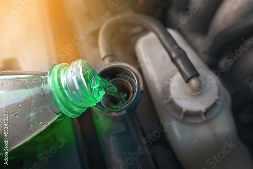 Canvas Print Green coolant pour from plastic bottle into car radiator