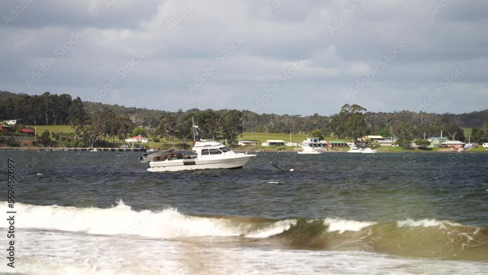 fishing boat moored to a buoy in rough swell and waves fishing boat moored to a buoy in rough swell and waves