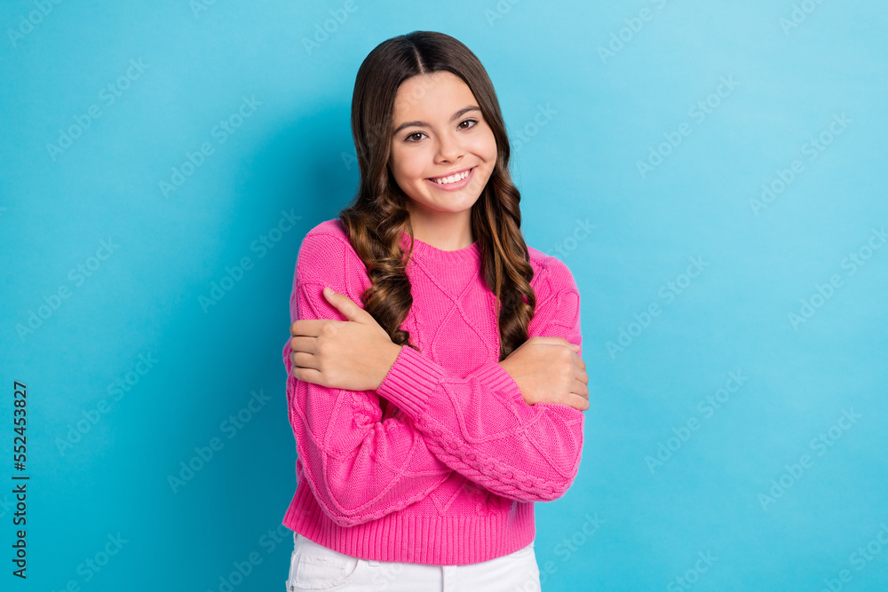 Photo of cute teenager school girl wear pink autumn season sweater hug herself enjoy her new clothes cold weather isolated on blue color background Photo of cute teenager school girl wear pink autumn season sweater hug herself enjoy her new clothes cold weather isolated on blue color background